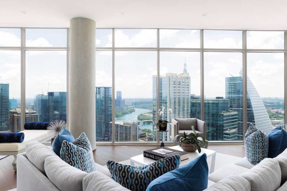 blue and white living room in penthouse suite with dark hardwood floors and wall to wall views